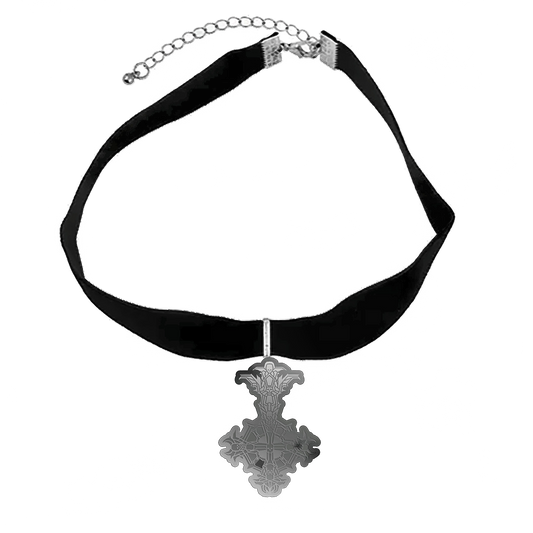 A silver choker necklace with a black velvet band and a cross pendant, presented on a black and white patterned background.